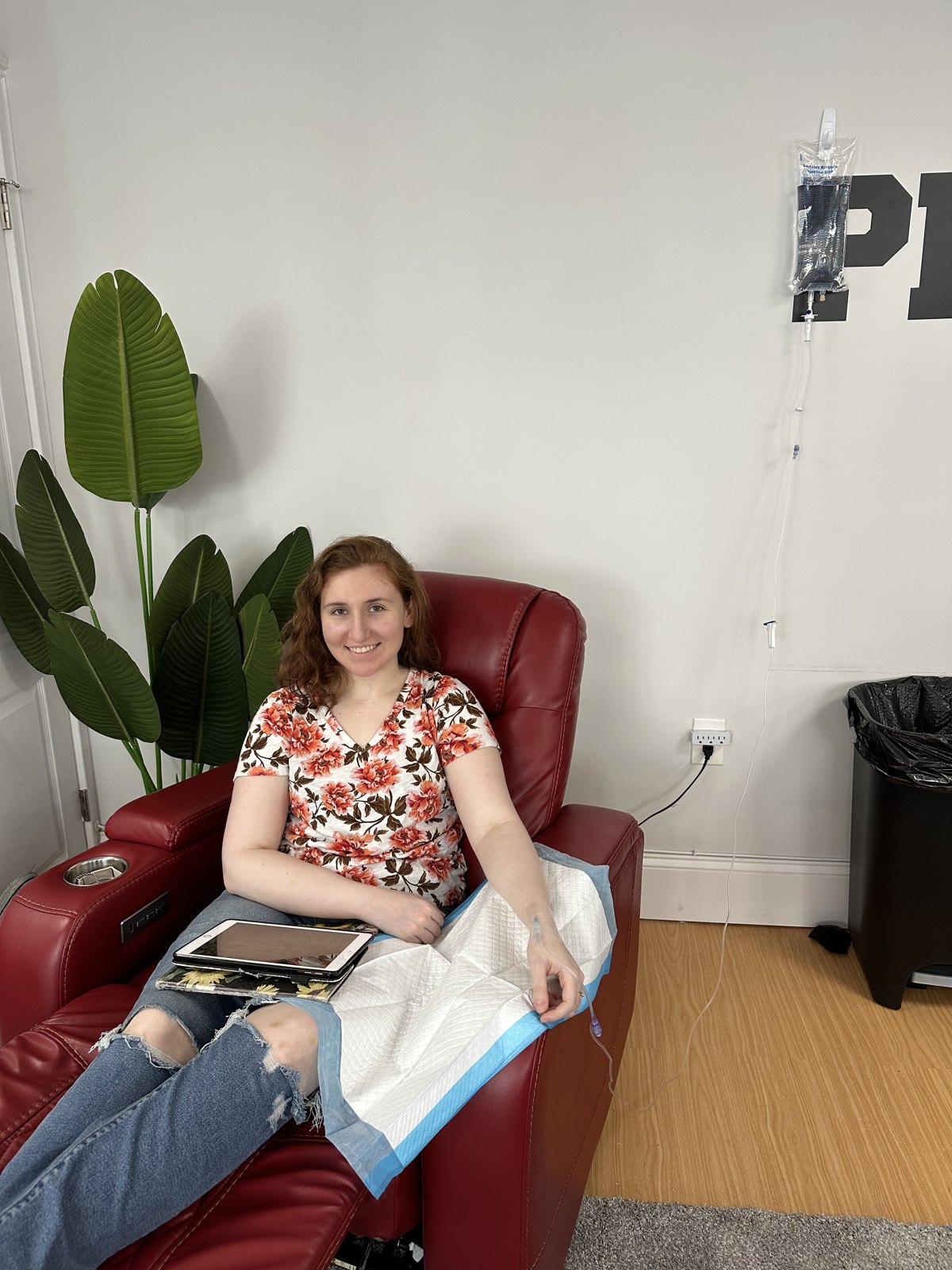 Client smiling in a recliner during a nurse-led IV infusion at IV League Hydration Boston