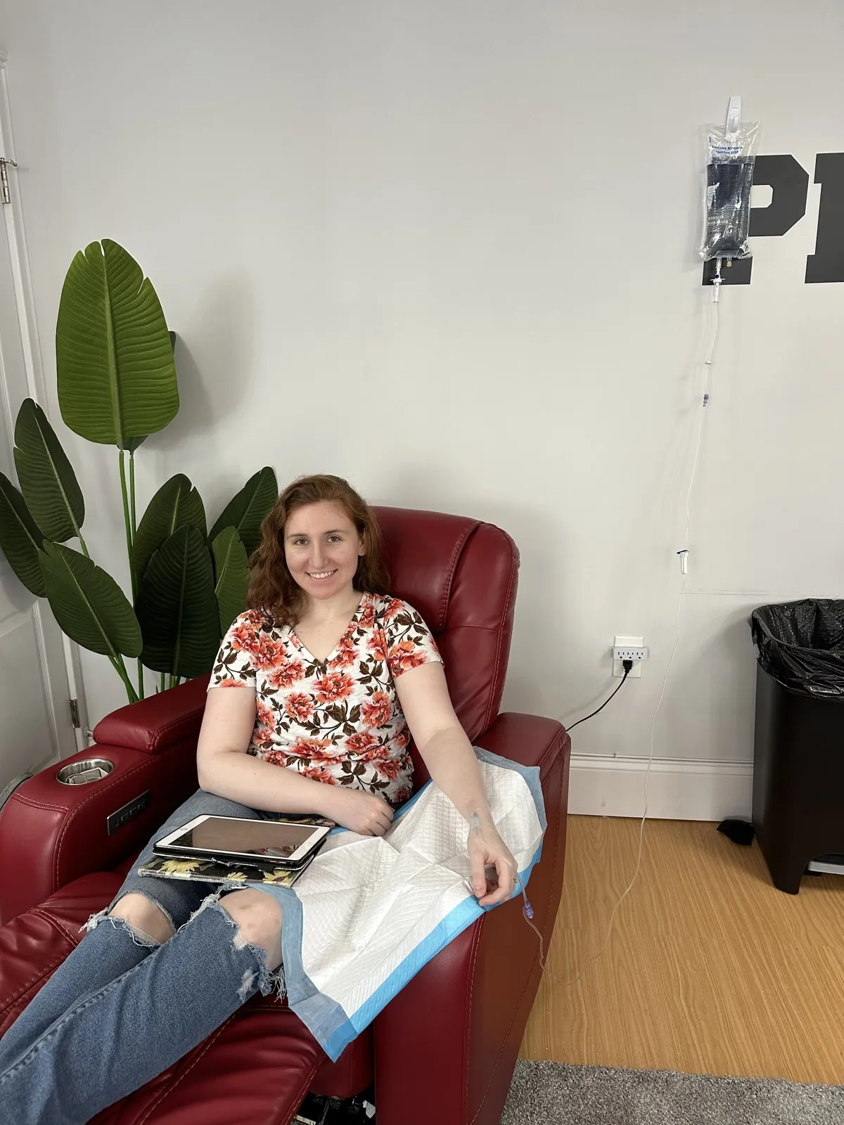 Client smiling in a recliner during a nurse-led IV infusion at IV League Hydration Boston
