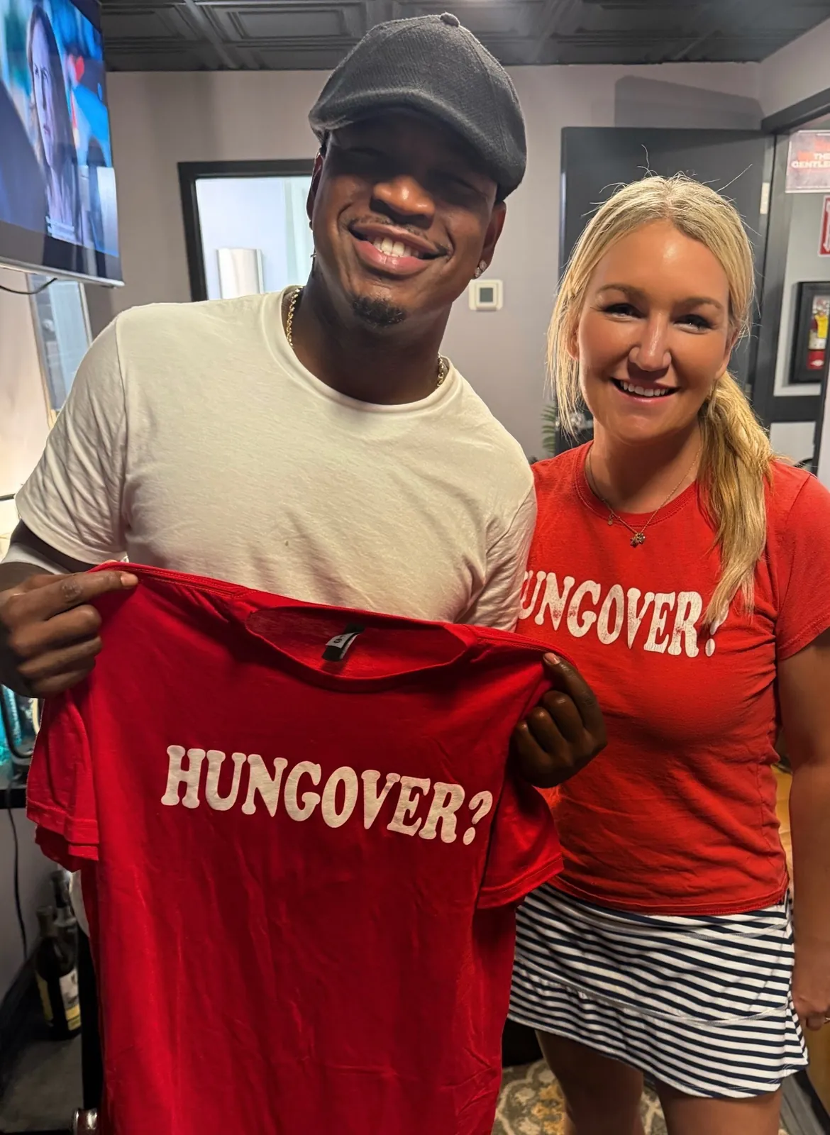 Recording artist holding an IV League Hydration Hungover? tee